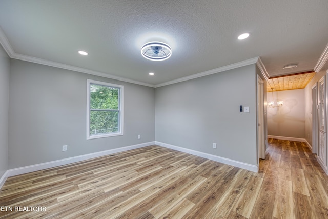 spare room featuring ornamental molding, a textured ceiling, and light hardwood / wood-style flooring