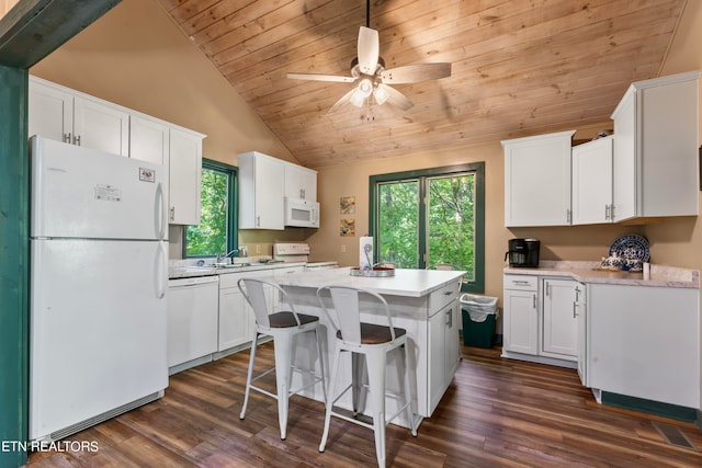 kitchen featuring white appliances, a kitchen island, white cabinetry, dark hardwood / wood-style floors, and vaulted ceiling