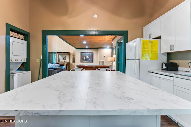 kitchen with white refrigerator, wood ceiling, white cabinetry, and stacked washing maching and dryer