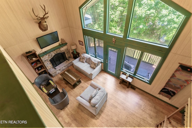 living room with a fireplace, hardwood / wood-style floors, and a high ceiling