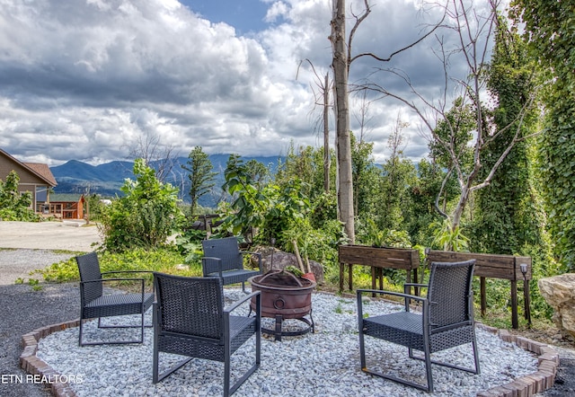 view of patio with a mountain view and an outdoor fire pit