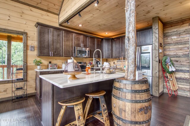 kitchen featuring wooden walls, dark brown cabinetry, dark hardwood / wood-style floors, lofted ceiling, and wooden ceiling