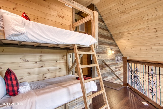 unfurnished bedroom featuring wooden ceiling, wooden walls, lofted ceiling, and hardwood / wood-style floors