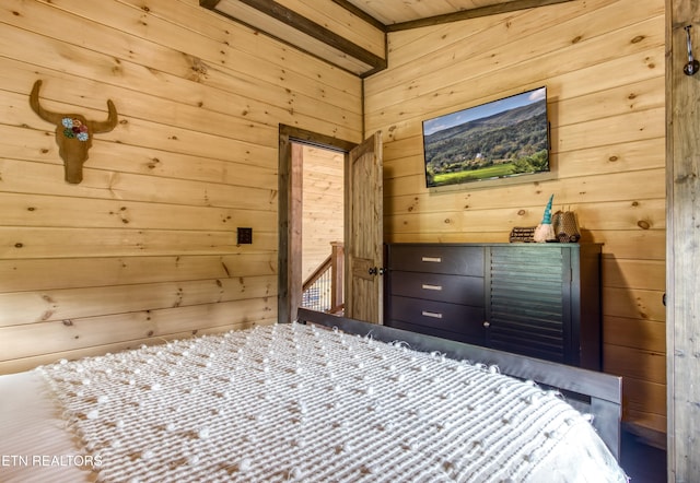 bedroom featuring wooden walls