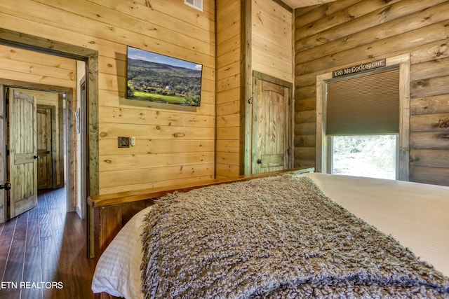 bedroom featuring rustic walls and hardwood / wood-style floors