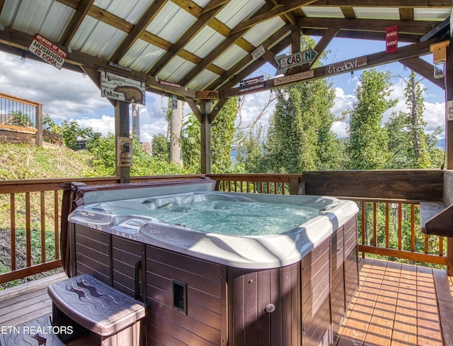 wooden deck with a hot tub and a gazebo