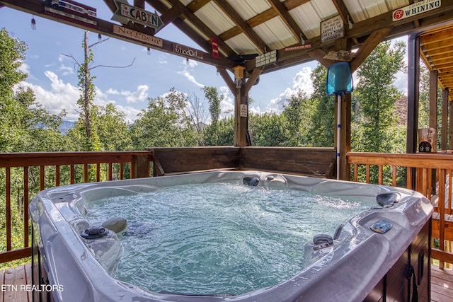 wooden deck featuring a hot tub