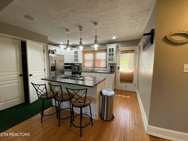 kitchen with sink, stainless steel appliances, white cabinets, and a kitchen island