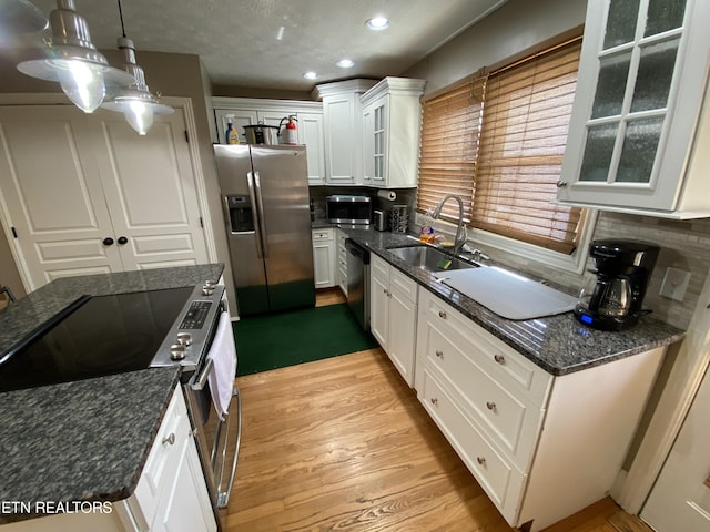 kitchen featuring sink, hanging light fixtures, white cabinets, and appliances with stainless steel finishes