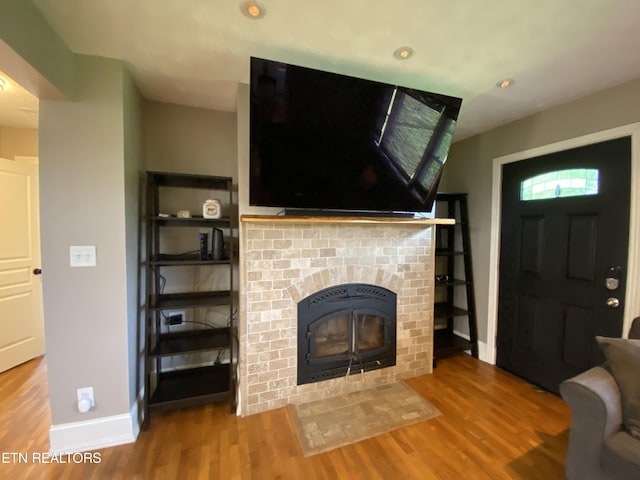 unfurnished living room featuring a brick fireplace and hardwood / wood-style floors