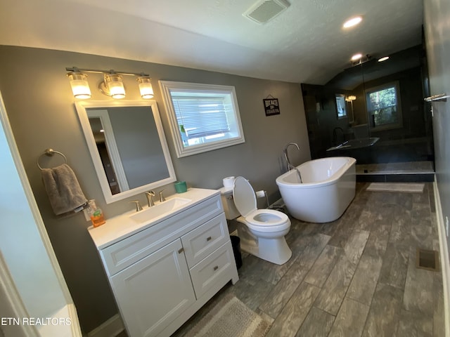 bathroom with lofted ceiling, toilet, vanity, a tub, and hardwood / wood-style flooring