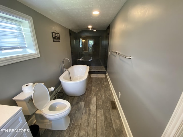 full bathroom with a wealth of natural light, independent shower and bath, wood-type flooring, vanity, and a textured ceiling