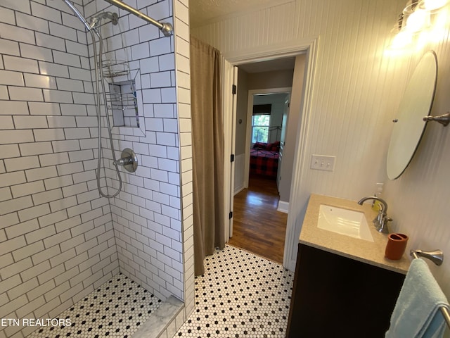 bathroom with tiled shower and vanity