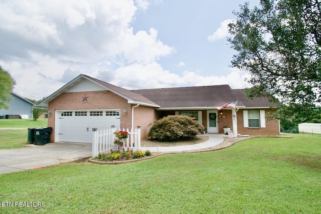 ranch-style house with a garage and a front lawn