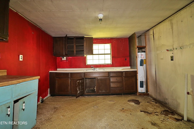 kitchen featuring wood walls, sink, water heater, and light tile patterned floors