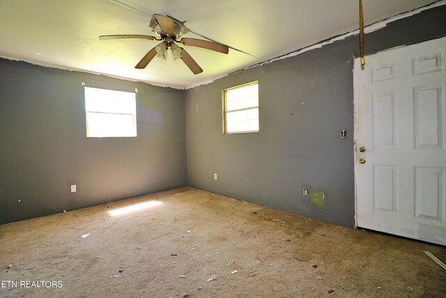 carpeted spare room with ceiling fan