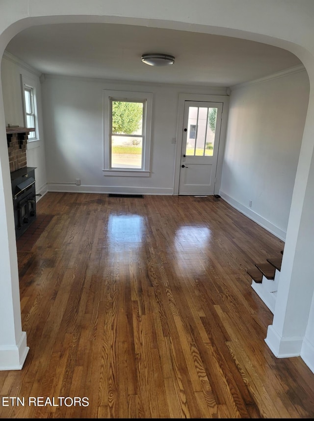 227 Gill St, Alcoa, TN 37701 - unfurnished living room featuring arched walkways, dark wood finished floors, plenty of natural light, stairway, and ornamental molding