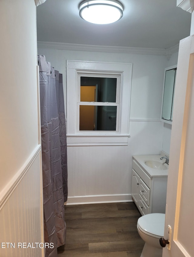 bathroom featuring vanity, ornamental molding, hardwood / wood-style flooring, and toilet