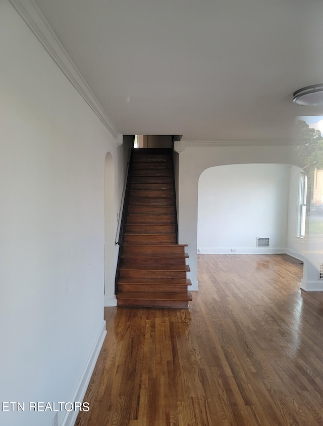 stairway featuring ornamental molding and hardwood / wood-style floors