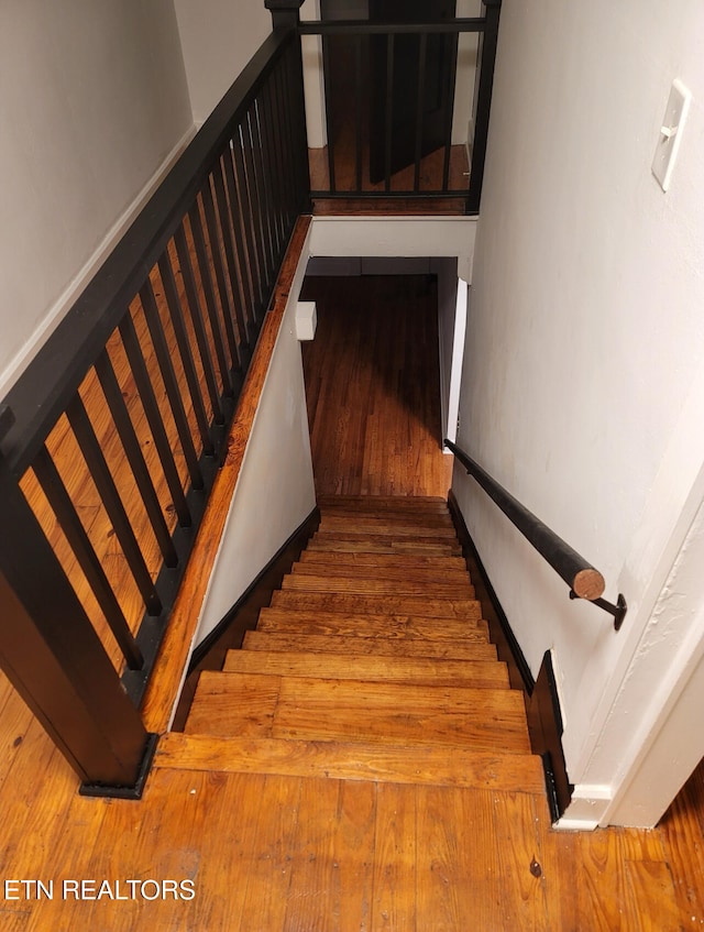 stairway featuring wood-type flooring