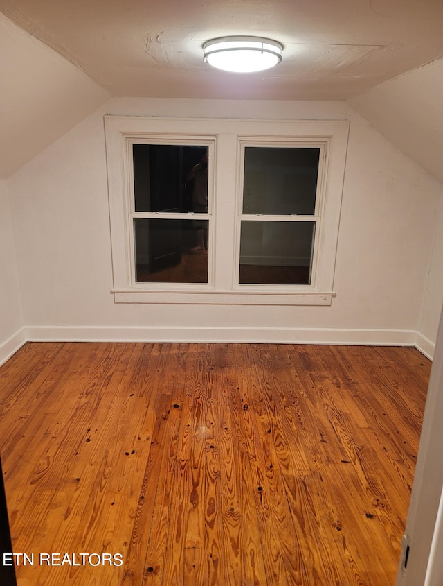 bonus room with vaulted ceiling and light hardwood / wood-style flooring