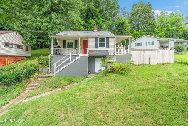 view of front of home with covered porch and a front lawn