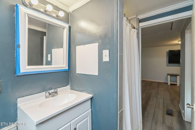 bathroom featuring vanity, wood-type flooring, and crown molding