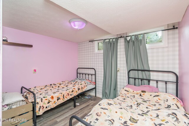 bedroom featuring a textured ceiling and wood-type flooring