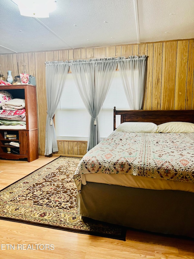 bedroom with light hardwood / wood-style floors and a textured ceiling