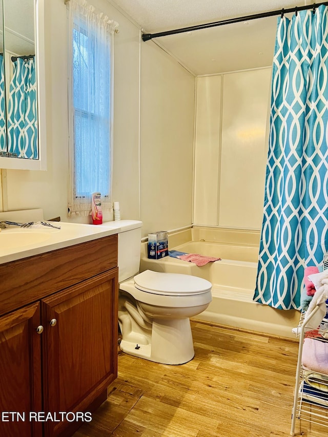 full bathroom with vanity, shower / bathtub combination with curtain, toilet, and wood finished floors