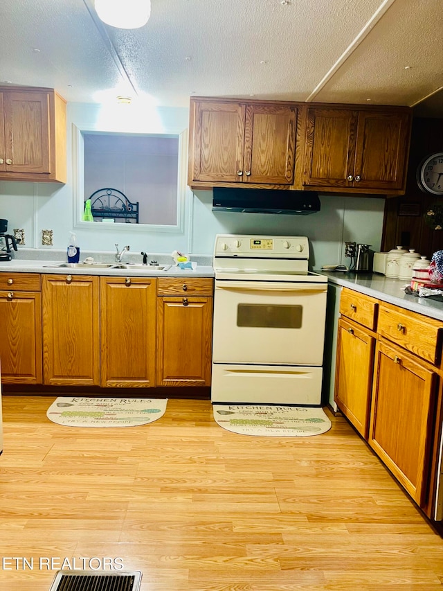 kitchen with electric range, light hardwood / wood-style flooring, ventilation hood, and a textured ceiling