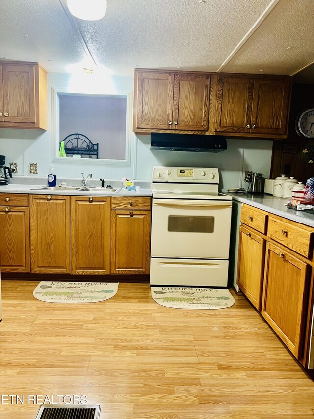 kitchen featuring light wood-type flooring, electric stove, extractor fan, and light countertops