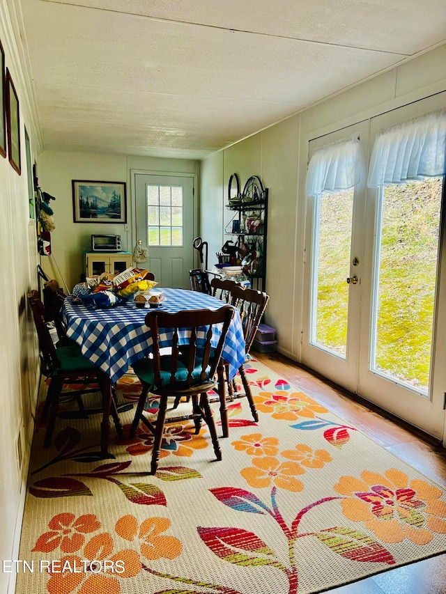 dining room featuring light hardwood / wood-style floors and a textured ceiling