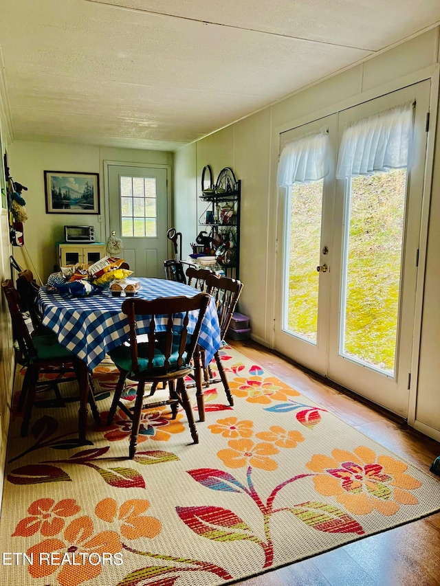 dining space with light hardwood / wood-style flooring and a textured ceiling