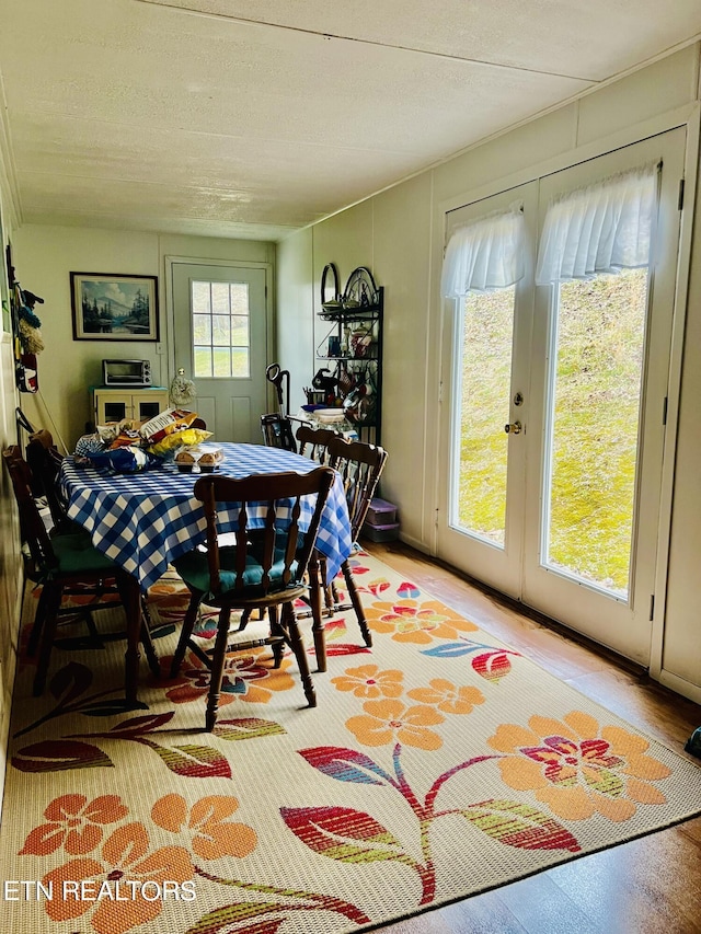 dining area featuring light wood-style flooring and french doors