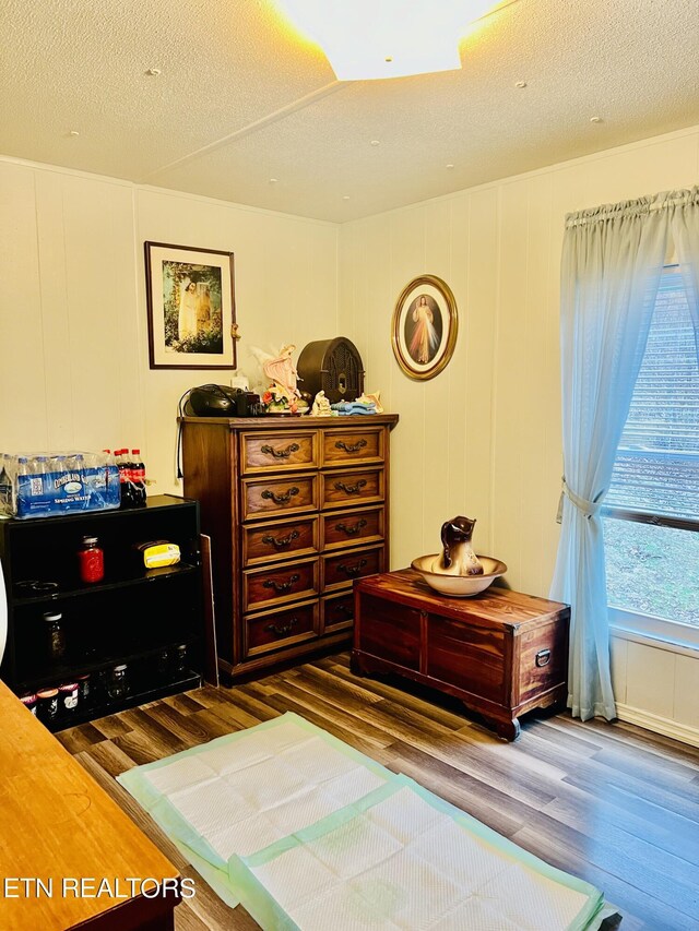 bedroom featuring a textured ceiling and wood finished floors