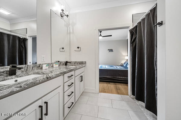 bathroom with dual bowl vanity, ornamental molding, and tile patterned floors