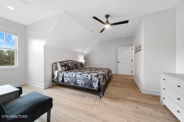 bedroom featuring light hardwood / wood-style flooring, vaulted ceiling, and ceiling fan