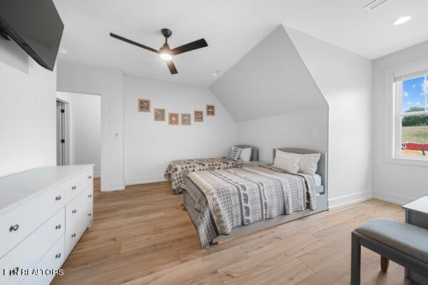 bedroom with ceiling fan, light wood-type flooring, and vaulted ceiling