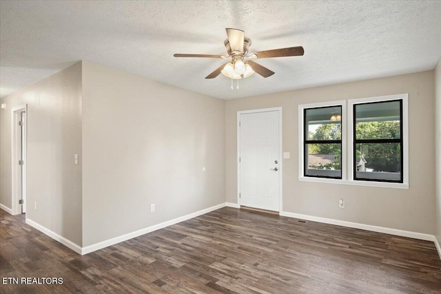 empty room with dark hardwood / wood-style flooring, ceiling fan, and a textured ceiling