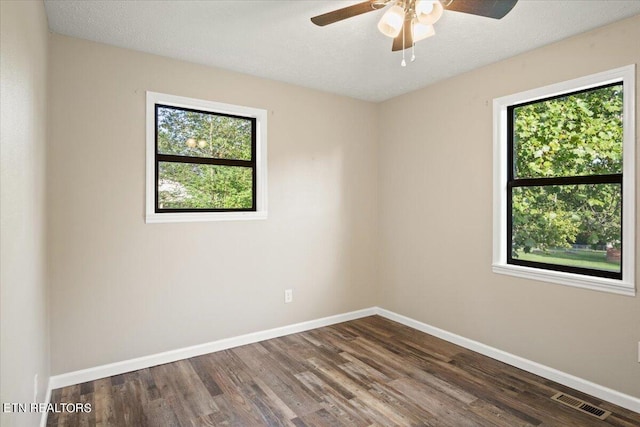 spare room featuring ceiling fan, dark hardwood / wood-style floors, and a textured ceiling