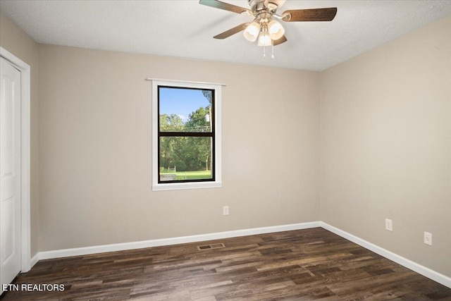 spare room with ceiling fan, a textured ceiling, and dark hardwood / wood-style flooring