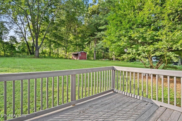 wooden terrace featuring a storage shed and a yard