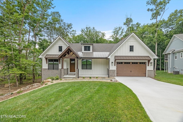 view of front of home with a porch, a garage, a front lawn, and central air condition unit