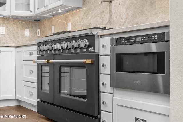kitchen featuring white cabinetry, wall oven, tasteful backsplash, and range with two ovens