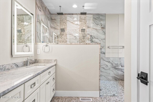 bathroom featuring a shower with shower door, tile patterned floors, and vanity