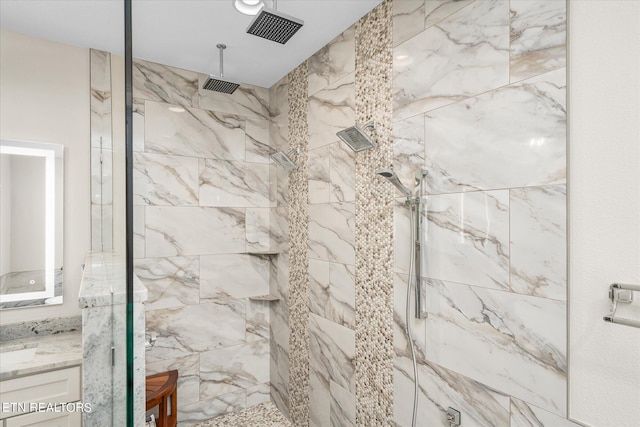 bathroom with a shower with shower door and vanity