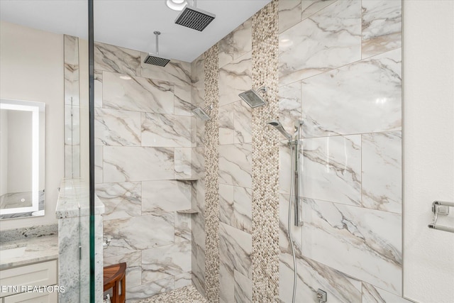 bathroom featuring vanity and tiled shower
