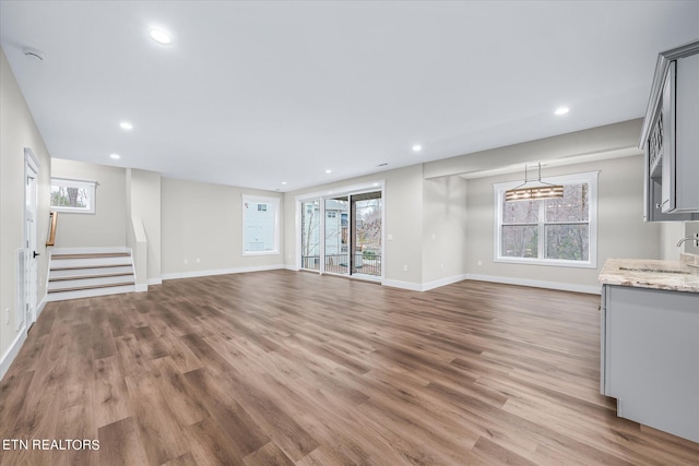 unfurnished living room featuring hardwood / wood-style floors and sink