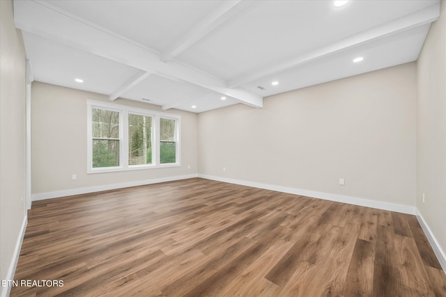 empty room with beamed ceiling and hardwood / wood-style flooring